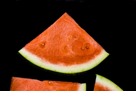Slices of red ripe sweet watermelon on black background, closeup , selective focus