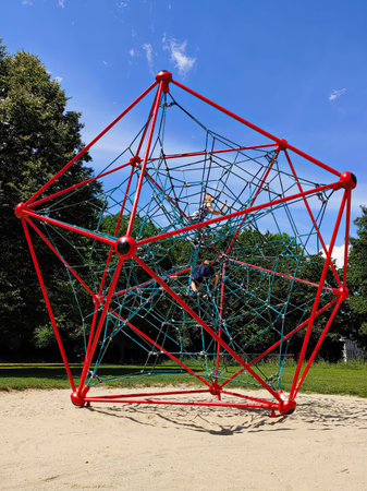 Young boy and girl climbing at gym jungle rope net in children playground