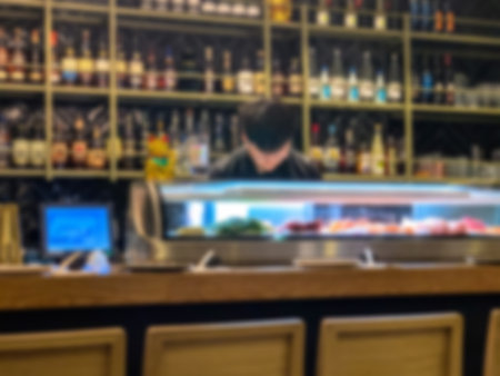 Blurred view of modern sushi bar with wine shelves in the backgroundの写真素材