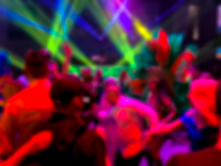 Dancing people at a party. Entertainment program at the wedding. Silhouettes of people dancing at a party. Blurred viewの写真素材