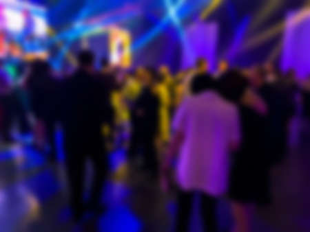 Dancing people at a party. Entertainment program at the wedding. Silhouettes of people dancing at a party. Blurred viewの写真素材