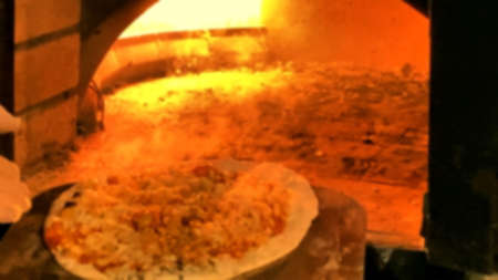 Pizza cooking in a gas brick portable oven, Blurred viewの写真素材