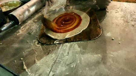 The process of making pizza from dough, tomato sauce and cheese.の写真素材