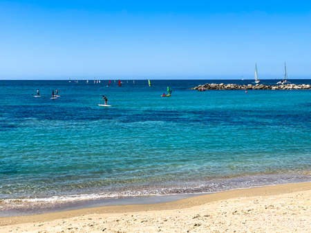 Mediterranean Sea. Yachts, windsurfing, paddle surfing on blue sky backgroundの写真素材