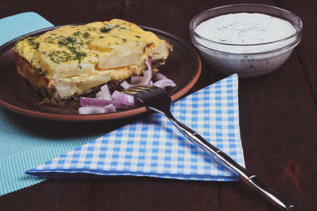 Cheese Casserole and cream sauce on the table. Hearty main dish. Vegetarian lunch. Cheese casserole with mushroomsの写真素材