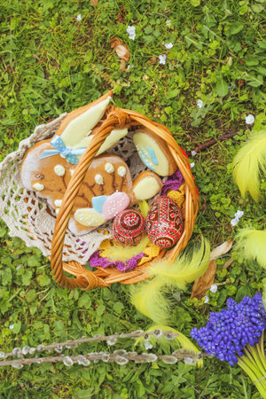 Gingerbread Easter Bunny in basket on a green lawn in the park. The Christian feast of Easter....