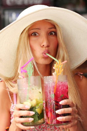 Beautiful girl is drinking few fresh and cool cocktails at hot summer dayの写真素材