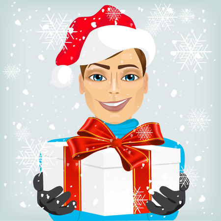 Young caucasian man wearing a santa hat offering a christmas gift decorated with a red ribbon, isolated on white backgroundのイラスト素材