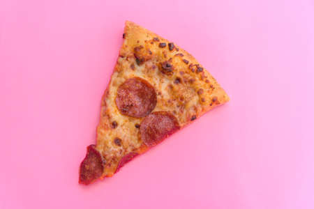 Pizza with pepperoni and cheese on pink backgroundの写真素材