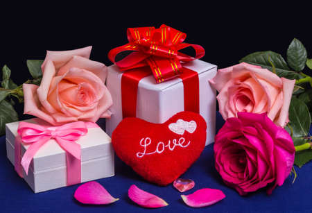 Heart with the inscription "Love", gifts and roses on a dark background. Greeting card for Valentine`s Day.の写真素材