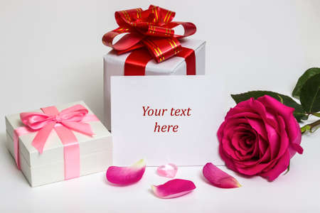 Gift box with a red ribbon and a rose. Neutral light background. Copy space.の写真素材