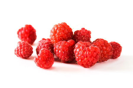 Bunch of a red raspberry on a white background. Close up macro shot.