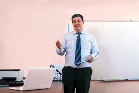 Teacher stands in front of blackboard. Teaching students in classroom college or university.の写真素材