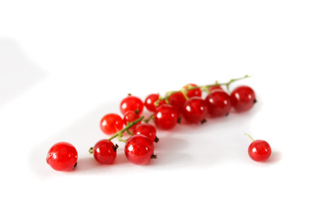 Transparent shiny berries of a red currant on a white background. Close-up. Spilled berries.