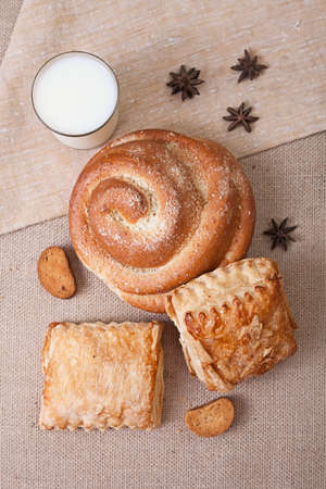 Fresh pastries and a glass of milk. Canvas tablecloth. Top view.の写真素材