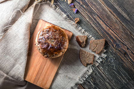 A loaf of bread and pieces of bread on an old wooden table. Authentic still life. The kitchen of the village house. Top view.の写真素材