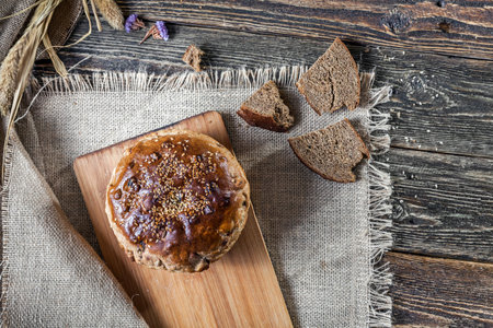 A loaf of bread and pieces of bread on an old wooden table. Authentic still life. The kitchen of the...