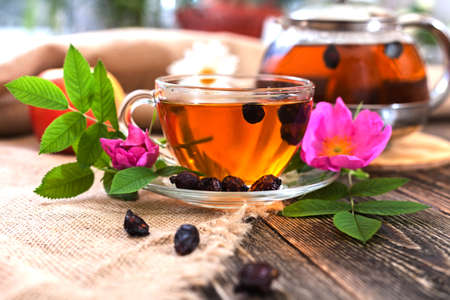 Tea with dried dog-rose on a wooden table. Home recipe. Healing tea with dried rosehip. Home country recipe.Top view.の写真素材