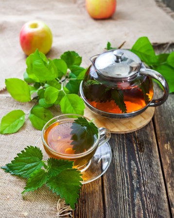 Healing tea with nettle. Tea in a glass cup on a wooden table. Folk remedy. The source of vitamins.の写真素材