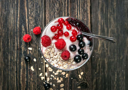 Delicious sweet dessert with currant and raspberries. Fruit yogurt with large ripe berries of raspberries and currants.の写真素材