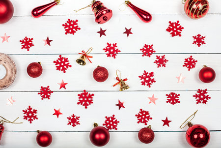 Christmas background - Christmas toys, snowflakes and bells on a light wooden background. Top view.