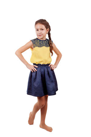 The girl is standing with her hands on her side. Isolated on white background.の写真素材