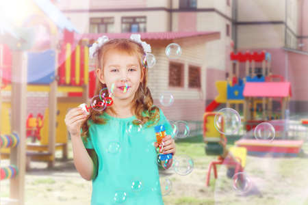 girl blows soap bubbles on a summer dayの写真素材