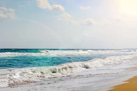 Tropical beach with a view to the sea. Sea waves rushing to the sandy beach and the blue sunny sky. Unreal picture.の写真素材