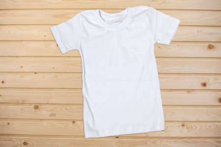 White Short Sleeve T-Shirt on a Wooden Background - Flat Layの写真素材