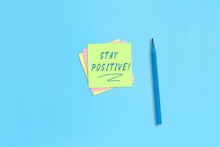 Sticky notes with handwritten inscription Stay positive! motivational statement.