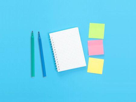 Notepad, markers and sticky notes on the desk. background for your design.