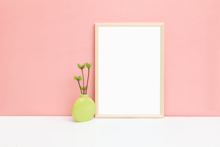 Mockup of a thin A4 wooden frame with twigs with swollen buds. Stylized image of a vertical frame....