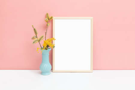 A4 size thin wood frame mockup with mimosa flowers. Stylized image of a vertical frame. Minimalistic spring layout for your design.の写真素材