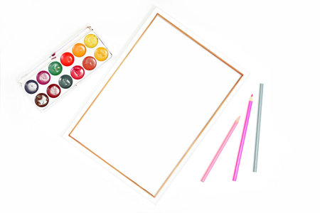 A stylized mockup of a white A4 frame with paints and colored pencils on a white background. Mockup...