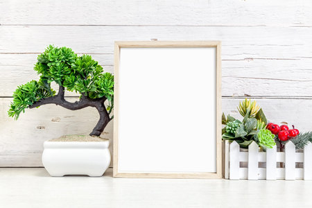 Mockup of a vertical wooden frame on a light background. Frame 8x10 on the table with a flower.の写真素材