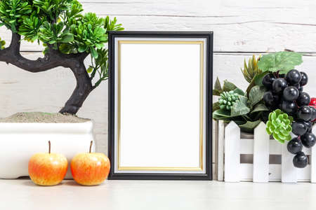 Mockup of a vertical black frame 10x15 cm on a light background. Black vertical frame with fruits on the table.の写真素材
