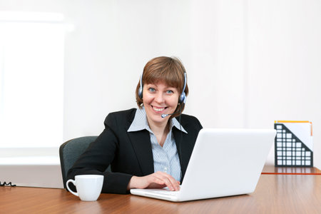 Pretty girl call center worker looks at the camera and smiles. call center or customer support...