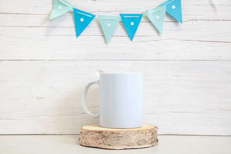 Mockup of a white ceramic mug with blue flags. White coffee mug on the table. Festive mockup.の写真素材