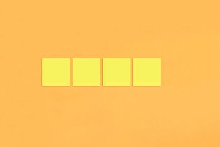 Yellow sticky notes on an orange background. background for your design.の写真素材