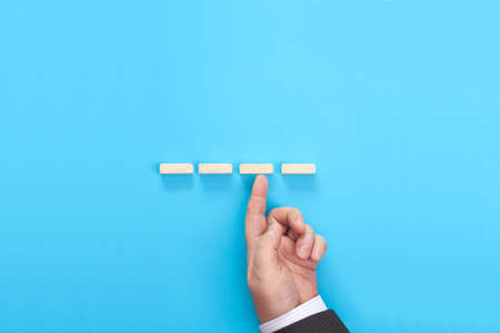 Hand of a businessman supporting wooden step. Business asset insurance and security concept.の写真素材