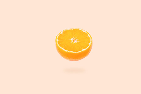 An orange hanging in the air. Half an orange floating in the air.