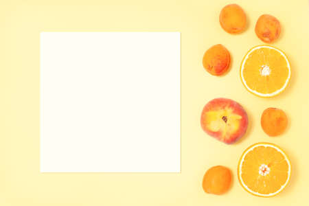 Mockup on yellow background with bright tropical fruits - blank paper for your designの写真素材