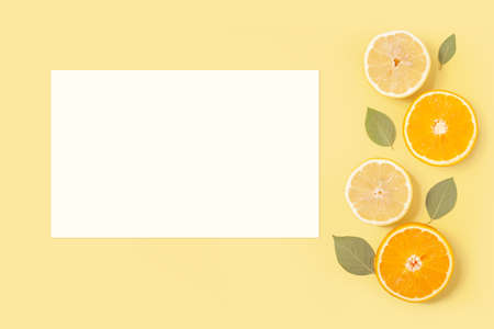 Summer tropical white paper card mockup on yellow background with tropical fruitsの写真素材