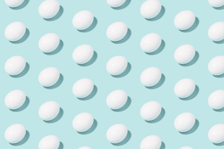 Creative minimalistic pattern - white chicken eggs on mint background - geometric pattern for creative backgroundの写真素材
