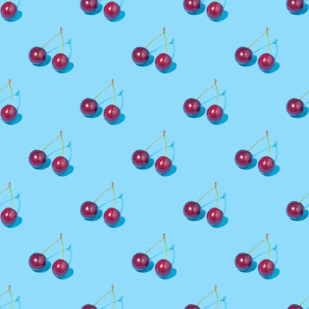 Seamless background with cherries - absolutely seamless pattern of cherries on a blue backgroundの写真素材