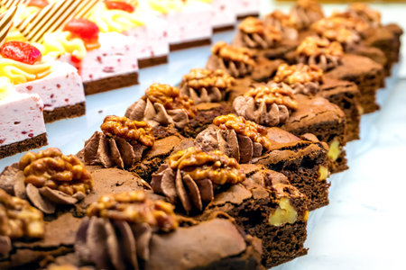 Chocolate brownies decorated with nuts. Close-up. Table setting in a restaurant.の写真素材