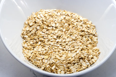 Oatmeal flakes on a white plate. Side view Ideal for content related to healthy eating and nutrition.の写真素材
