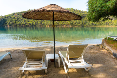 Blue Lagoon is a tropical resort in Oludeniz, Turkey. Sun loungers and umbrellas along the beach, overlooking the blue lagoon.の写真素材