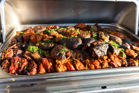 Stuffed eggplants and peppers simmered in a tomato sauce with spices, arranged on a large tray. A savory dish featuring vibrant vegetables and rich flavors. Selective focus.の写真素材