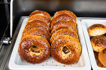 Freshly baked bagels with a golden brown crust and sesame seed topping. Warm and aromatic, straight...
